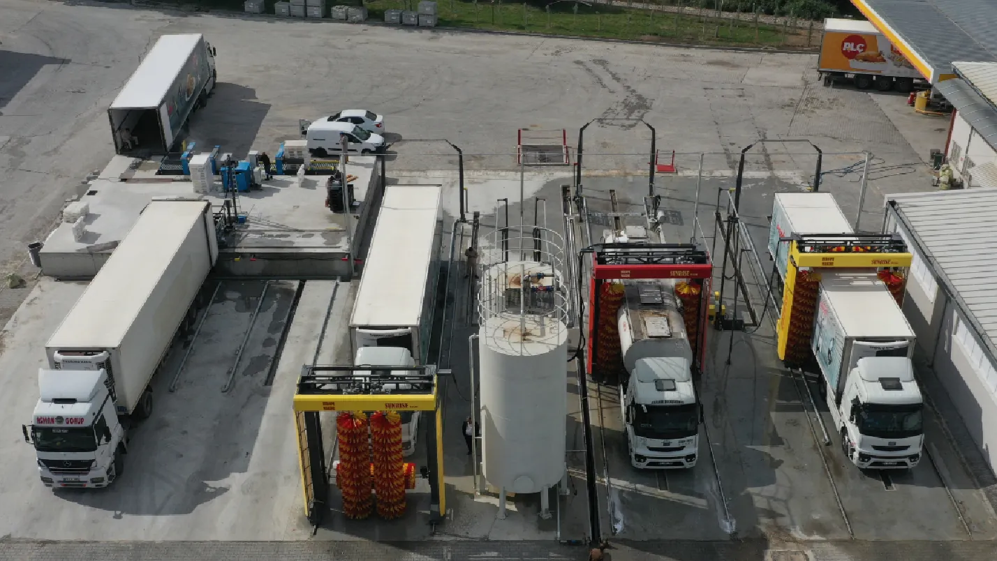 Three Europe Makine gantries washing articulated lorries and rigid trucks across a multi-bay depot